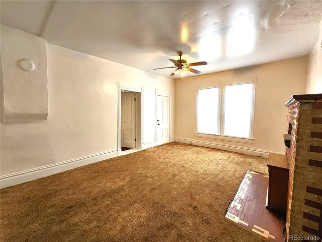 a view of empty room with fan and fireplace