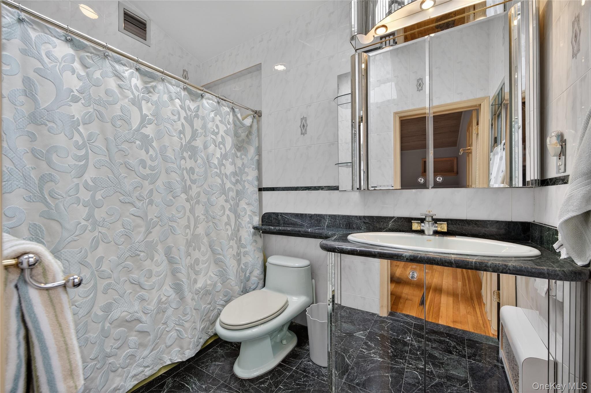 43 Highwood Road East Norwich, NY 11732 - Photo 17 of 32 a bathroom with a granite countertop sink toilet and mirror
