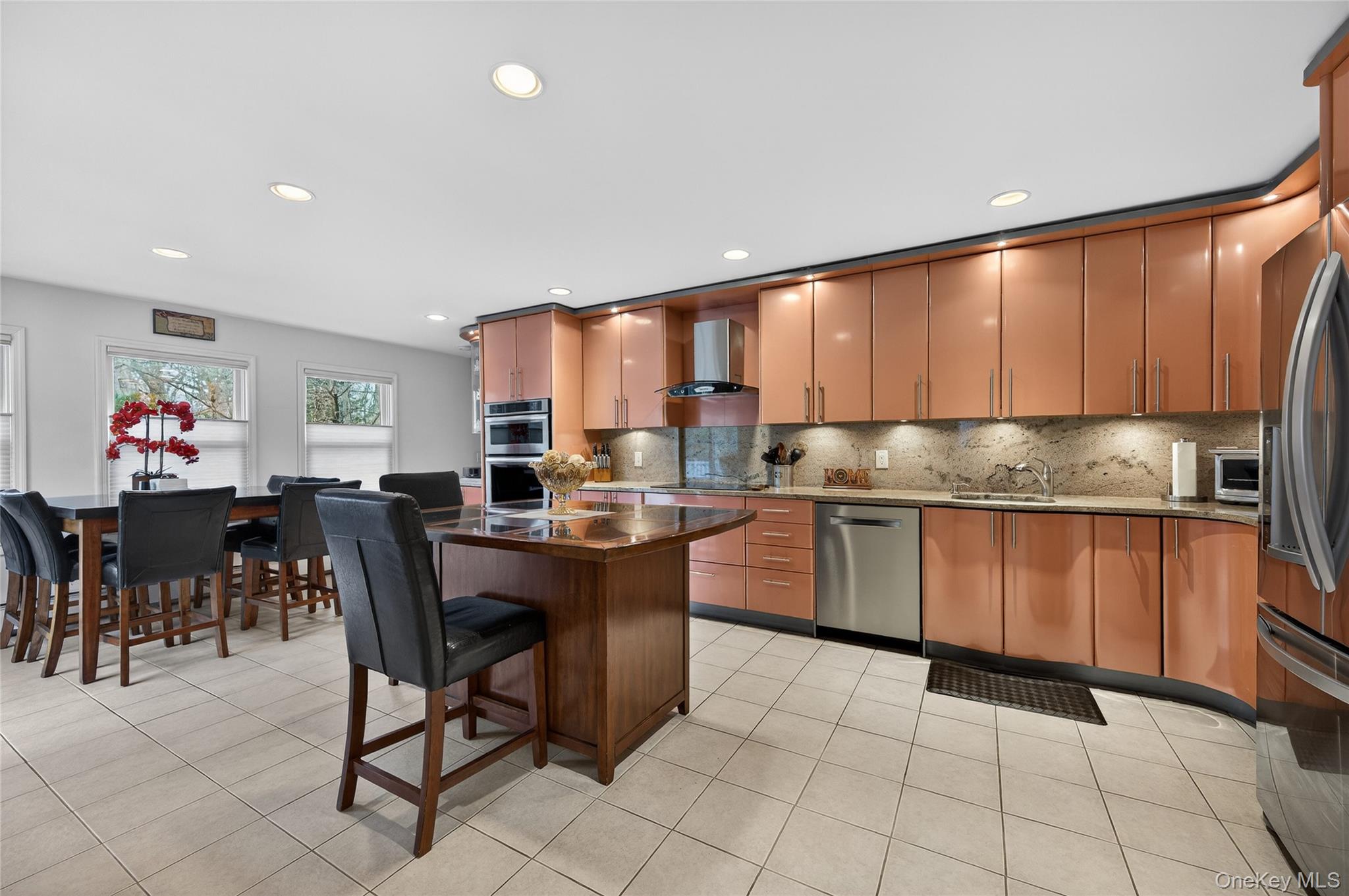 43 Highwood Road East Norwich, NY 11732 - Photo 7 of 32 a kitchen with stainless steel appliances granite countertop a table chairs sink and cabinets
