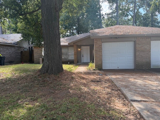 a view of a house with a yard and large tree
