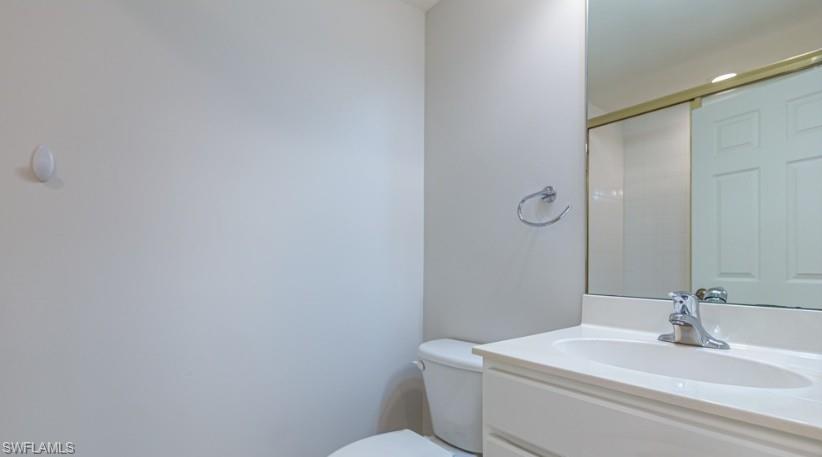 9113 Michael Circle, Unit 9 Naples, FL 34113 - Photo 17 of 28 a bathroom with a sink a toilet and a mirror