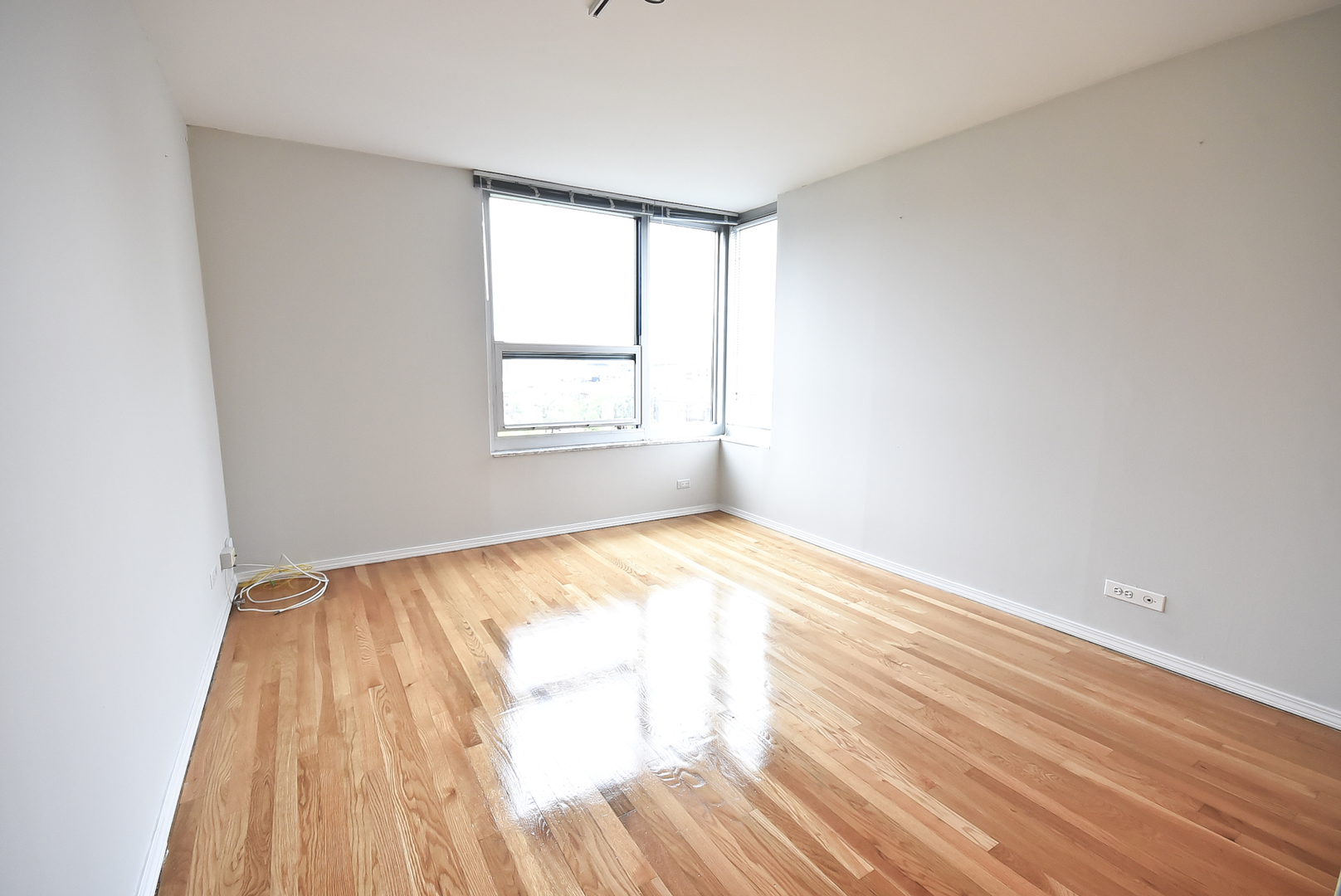 720 West Gordon Terrace, Unit 8L Chicago, IL 60613 - Photo 11 of 15 an empty room with wooden floor and windows