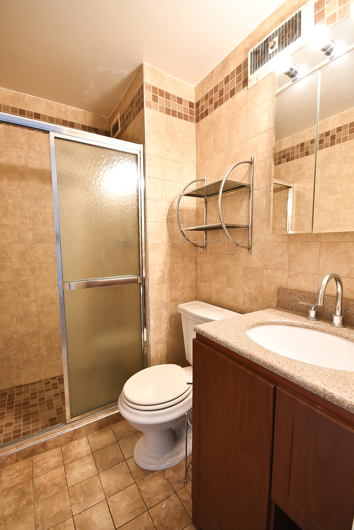 720 West Gordon Terrace, Unit 8L Chicago, IL 60613 - Photo 13 of 15 a bathroom with a granite countertop sink toilet and shower