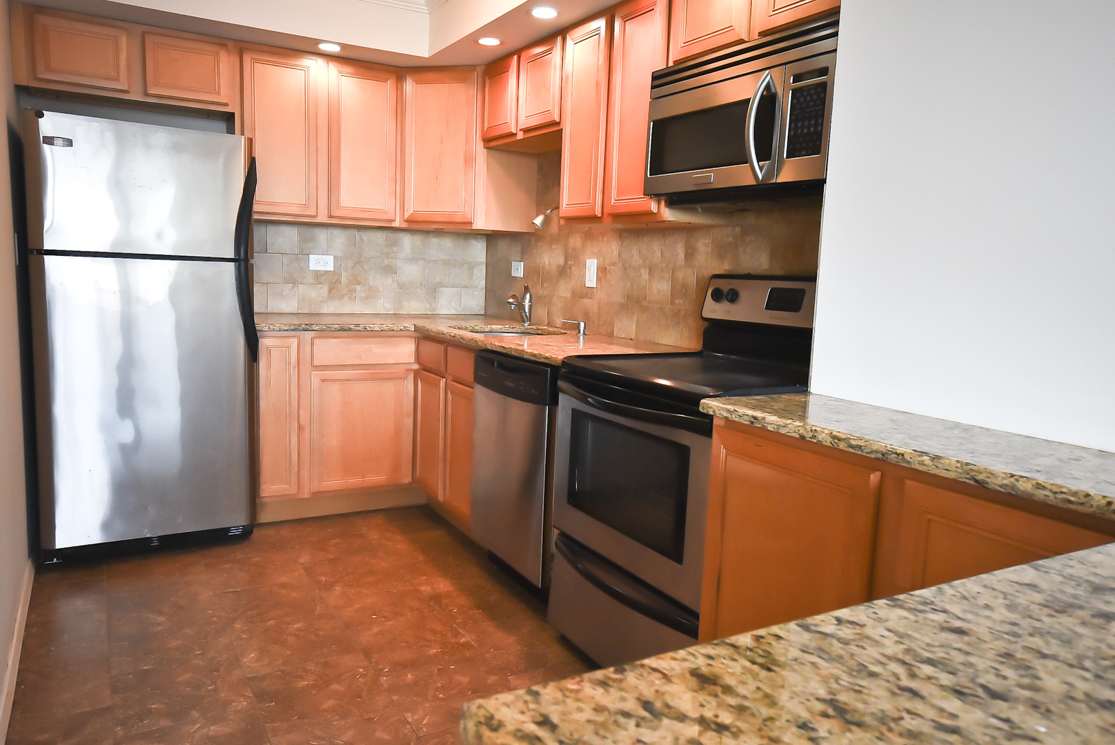 720 West Gordon Terrace, Unit 8L Chicago, IL 60613 - Photo 8 of 15 a kitchen with stainless steel appliances granite countertop a refrigerator a stove a sink and a microwave