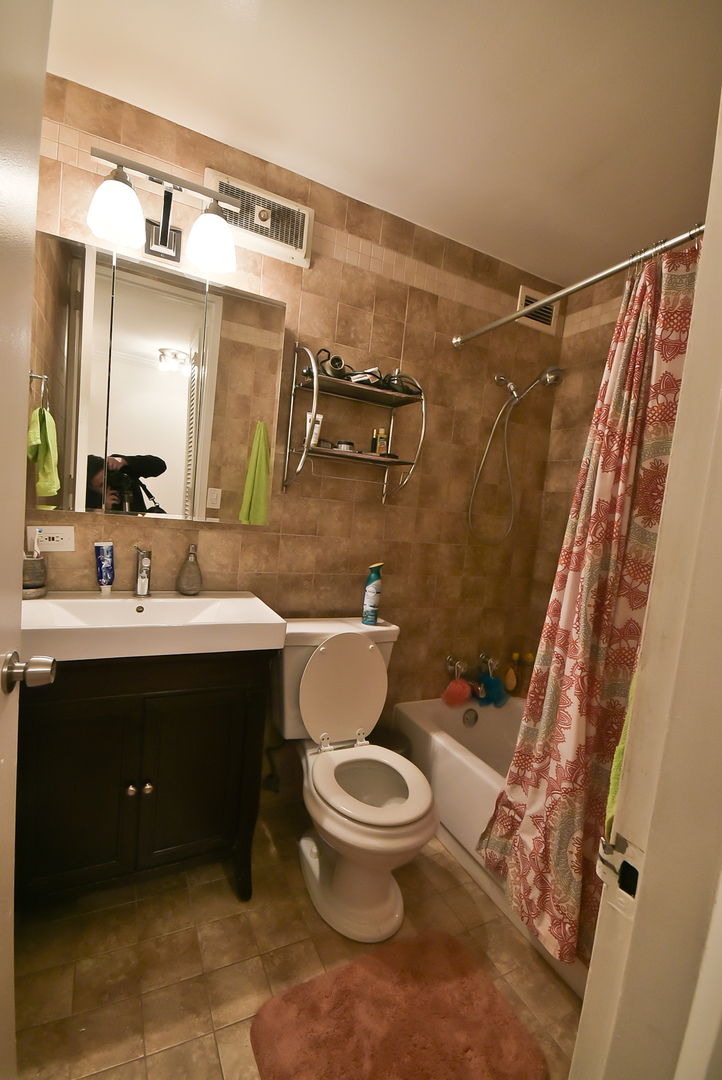 720 West Gordon Terrace, Unit 8L Chicago, IL 60613 - Photo 10 of 15 a bathroom with a sink vanity mirror and toilet