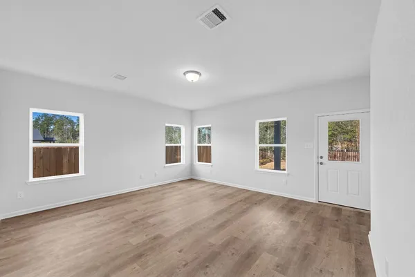 a view of a big room with windows and chandelier fan