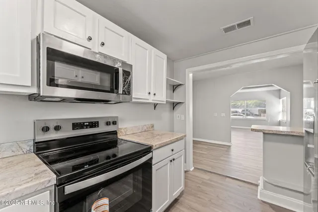 a kitchen with stainless steel appliances a stove microwave and cabinets