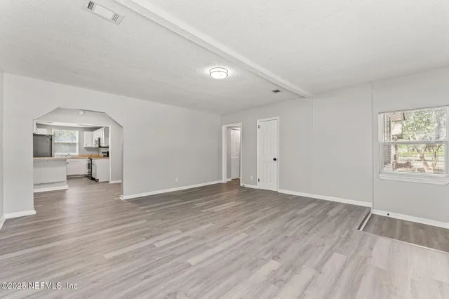 wooden floor in an empty room with a window