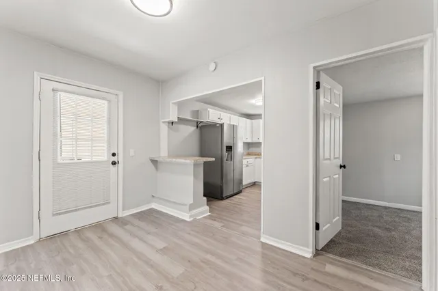 a view of a hallway with wooden floor and closet area