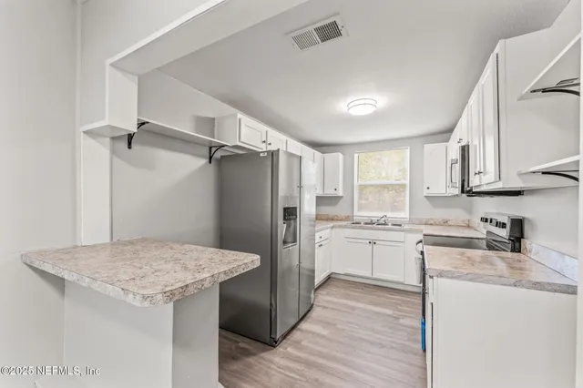 a kitchen with refrigerator cabinets and wooden floor