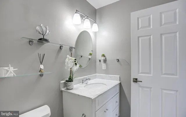 a bathroom with a sink and mirror with toilet
