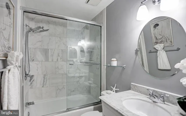 a bathroom with a granite countertop shower a sink and mirror