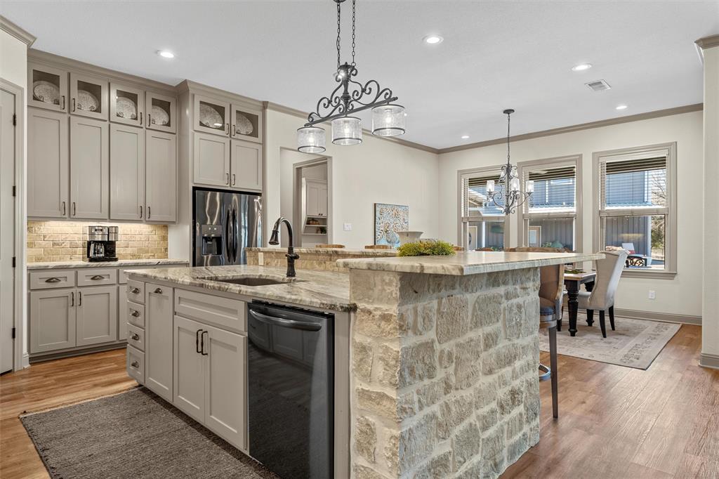 18503 Wortham Bend Road China Spring, TX 76633 - Photo 13 of 40 a kitchen with kitchen island granite countertop a sink cabinets and stainless steel appliances