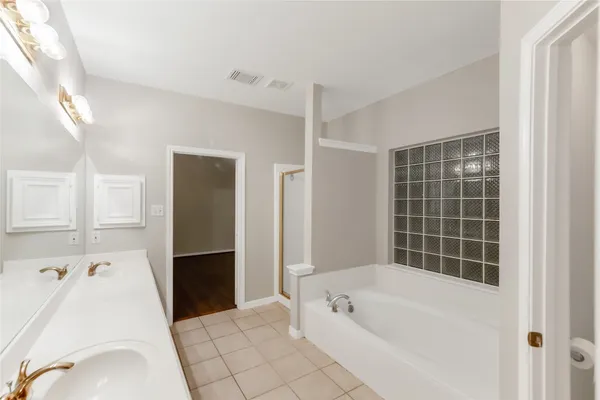 a large bathroom with a tub sink shower and mirror