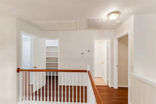 a view of staircase with railing and white walls