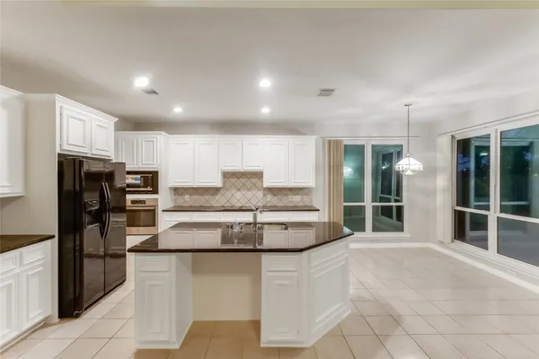 a kitchen with stainless steel appliances granite countertop a refrigerator and a sink