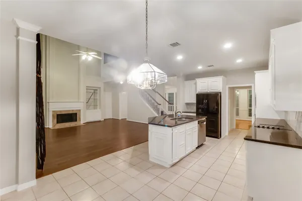 a view of a hallway with wooden floor and a bathroom