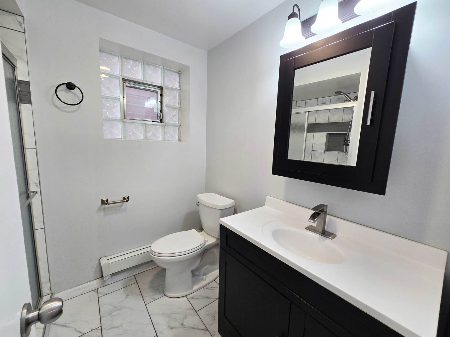 5972 South Archer Avenue, Unit GN Chicago, IL 60638 - Photo 10 of 16 a bathroom with a sink a toilet and mirror