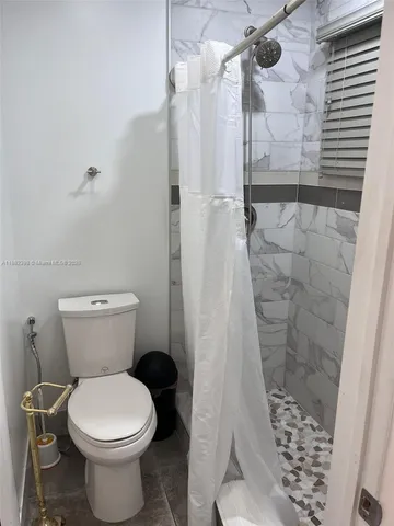 a bathroom with a toilet and a shower