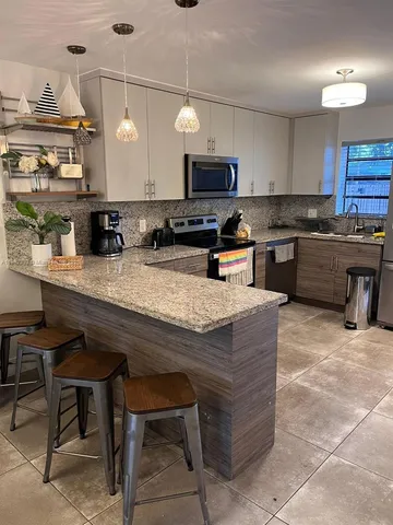 a kitchen with a stove a sink a microwave and wooden cabinets
