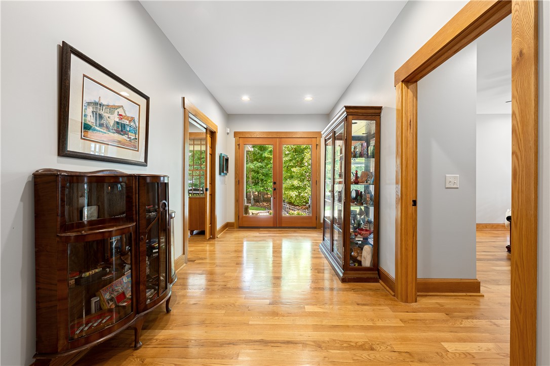 285 Bertha Allen Road Westminster, SC 29693 - Photo 7 of 50 Hardwood floors guide you through this inviting hallway, culminating in bright French doors overlooking natural scenery.