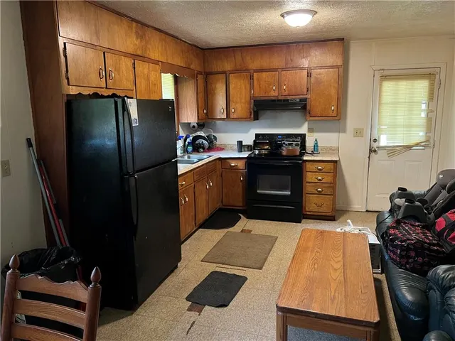 a kitchen with stainless steel appliances granite countertop a refrigerator and a stove