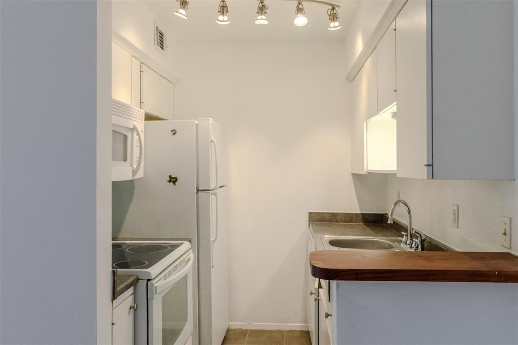 4859 Cedar Springs Road, Unit 234 Dallas, TX 75219 - Photo 16 of 22 a bathroom with a sink a mirror and shower
