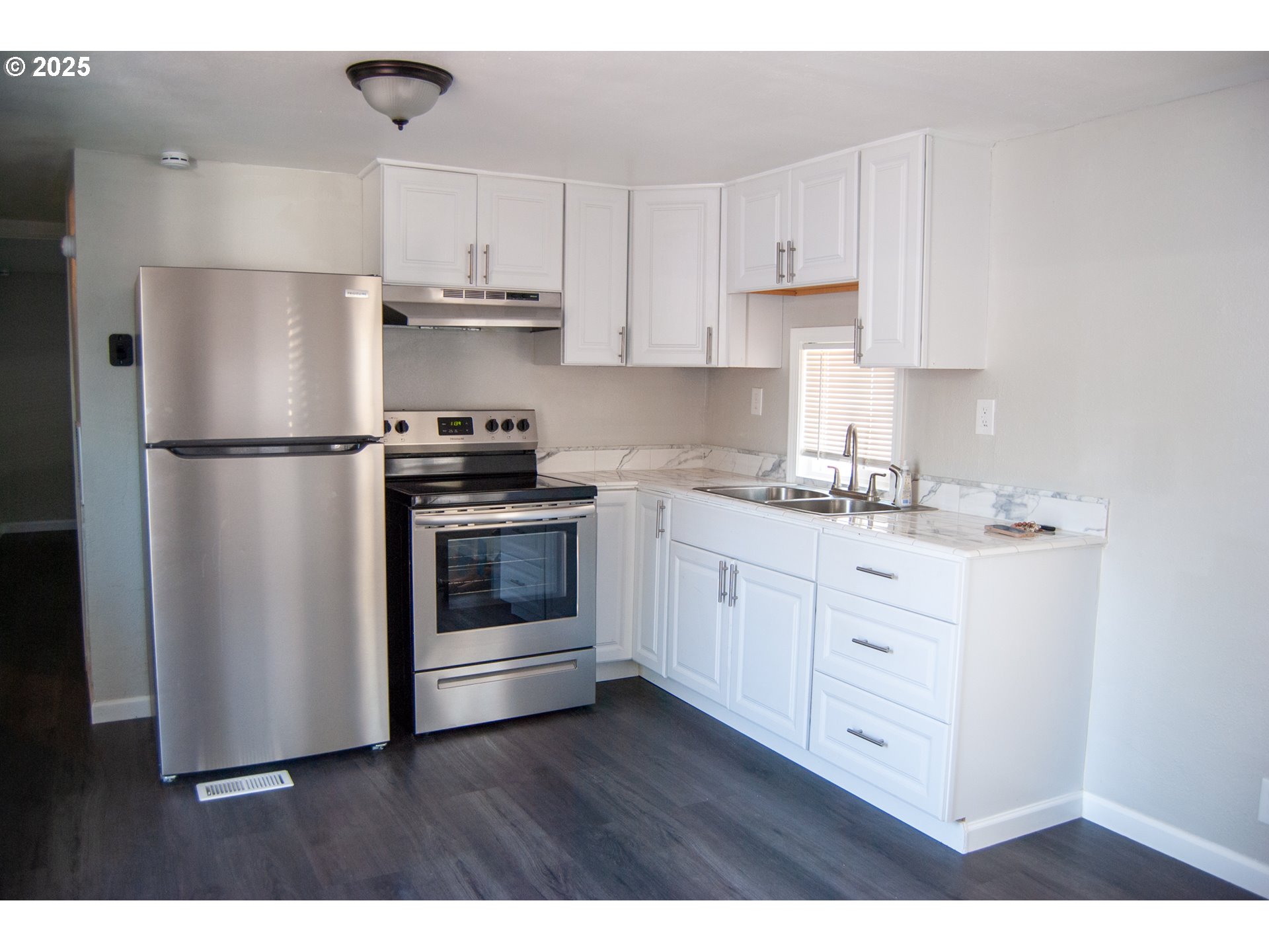 10901 Southeast Powell Boulevard, Unit 33 Portland, OR 97266 - Photo 5 of 12 a kitchen with appliances a sink and a refrigerator