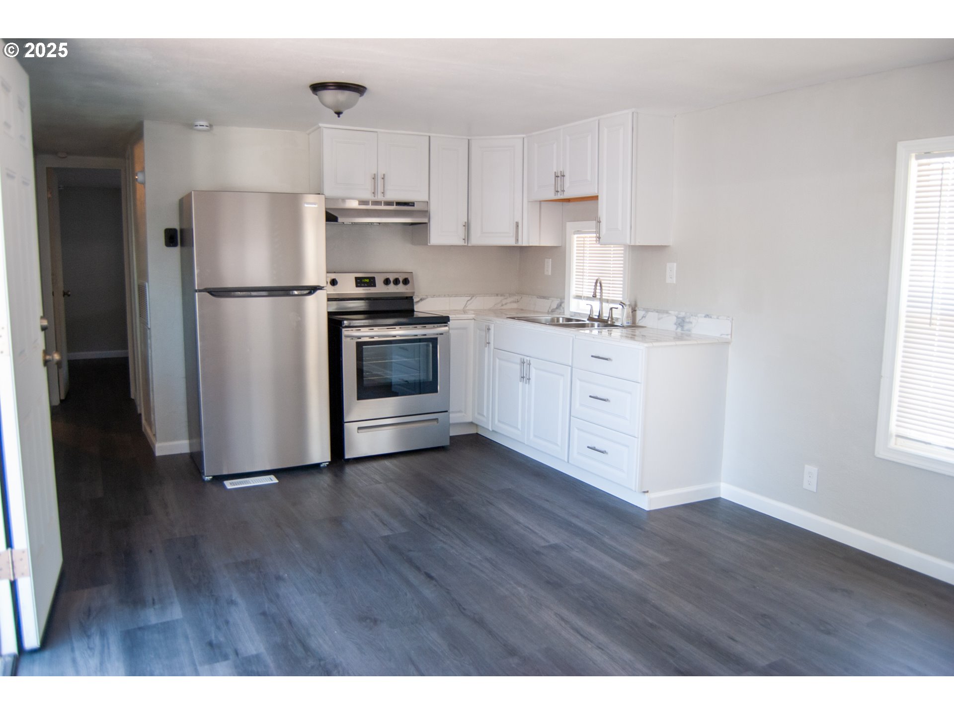 10901 Southeast Powell Boulevard, Unit 33 Portland, OR 97266 - Photo 6 of 12 a kitchen with stainless steel appliances white cabinets and a refrigerator