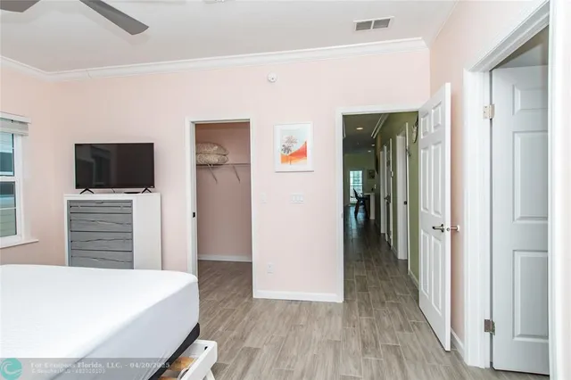 a view of a livingroom with wooden floor and kitchen space