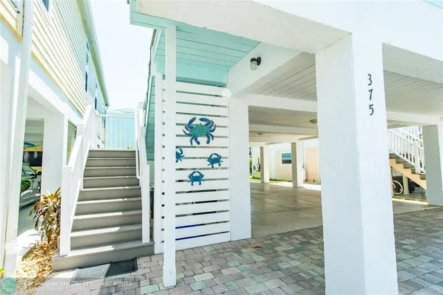 a view of a hallway with stairs and a living room