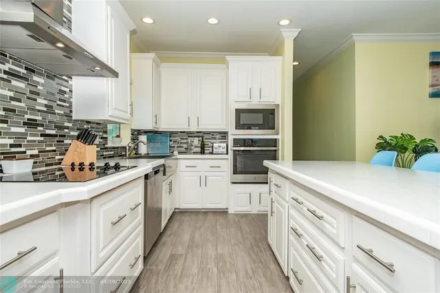 a kitchen with white cabinets and white appliances