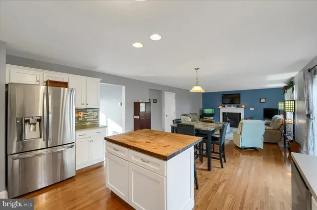 a large kitchen with kitchen island a stove a sink a counter top space and living room view