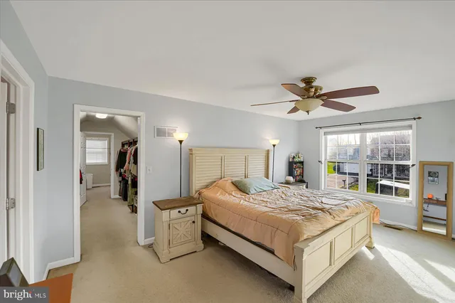 a bedroom with a bed dresser and a flat tv screen