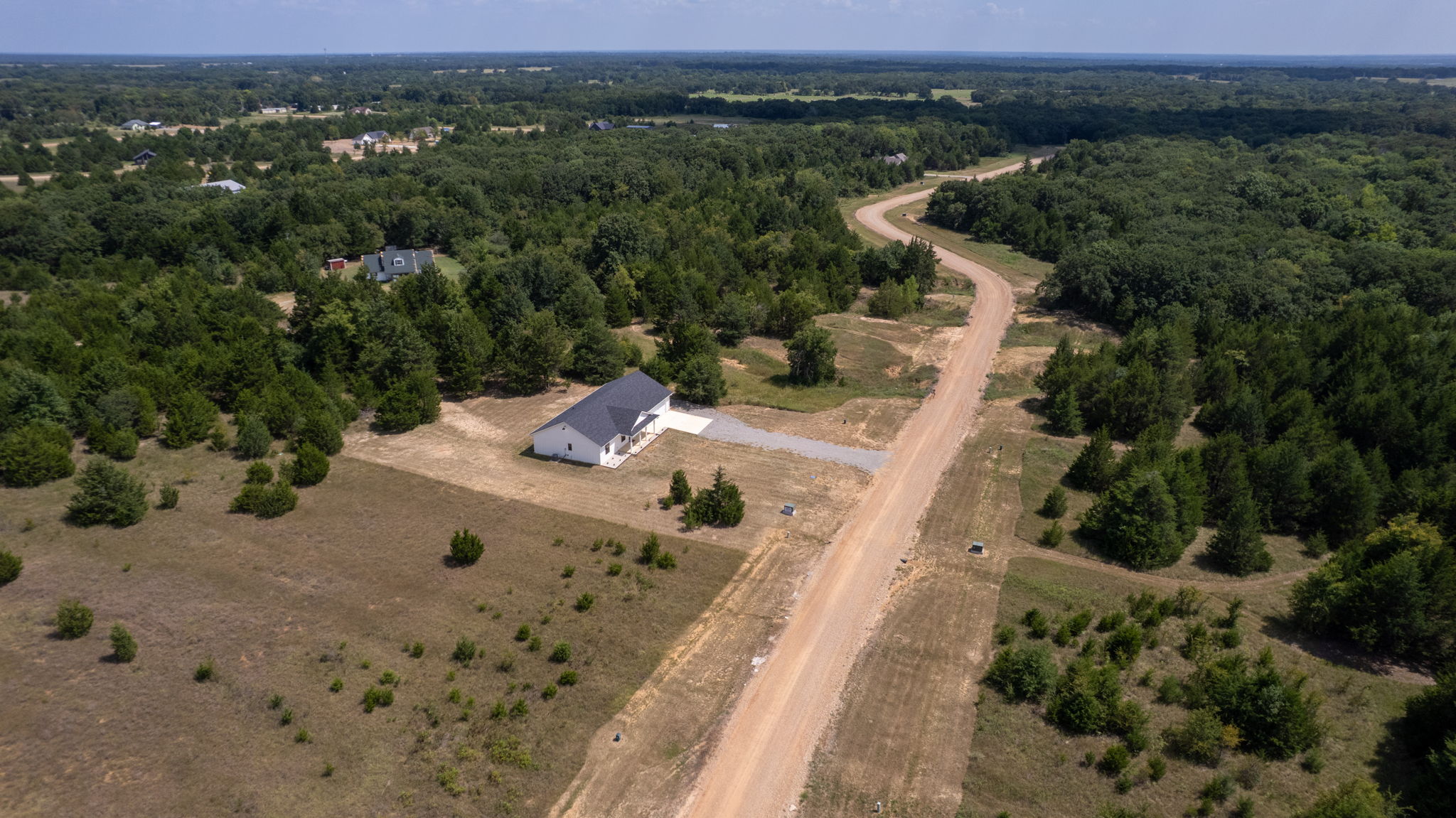 63 Deerfield Road Colbert, OK 74733 - Photo 33 of 33 New construction single-story residence featuring a white exterior with dark roof, situated on an expansive lot