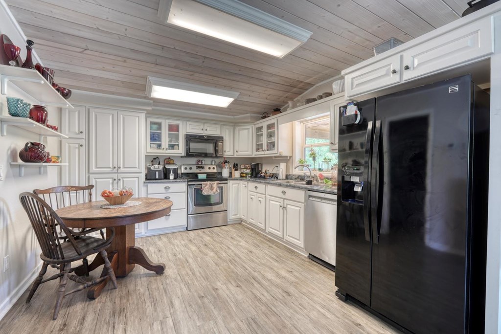 710 Town Mountain Road Hayesville, NC 28904 - Photo 68 of 68 a kitchen with a table chairs refrigerator and cabinets