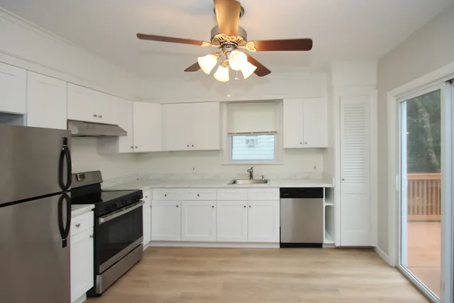 a kitchen with a sink a refrigerator and cabinets