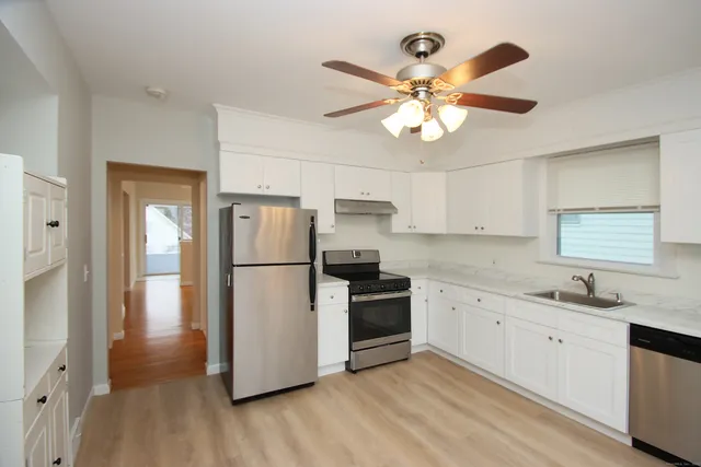 a kitchen with white cabinets and stainless steel appliances