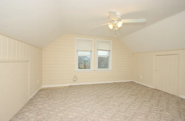 an empty room with fan and entrance
