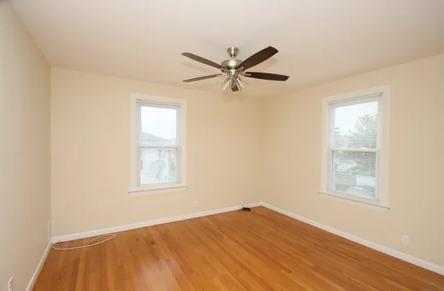 a view of a big room with wooden floor closet and windows