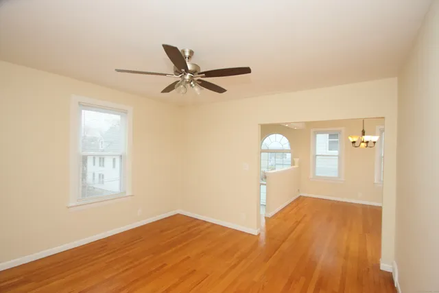 an empty room with windows and fan