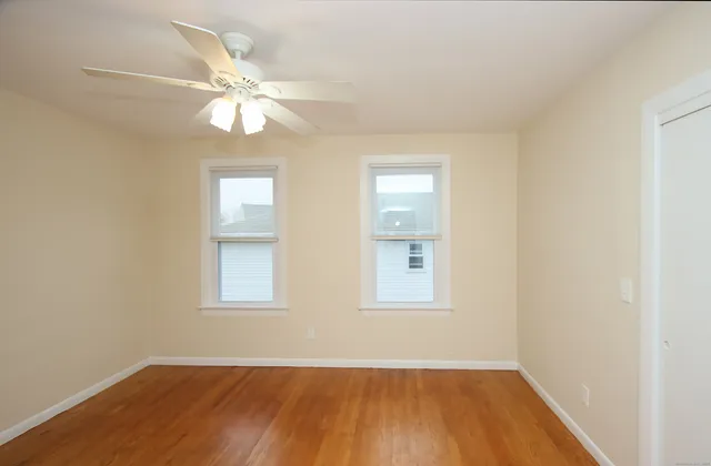 an empty room with windows and fan