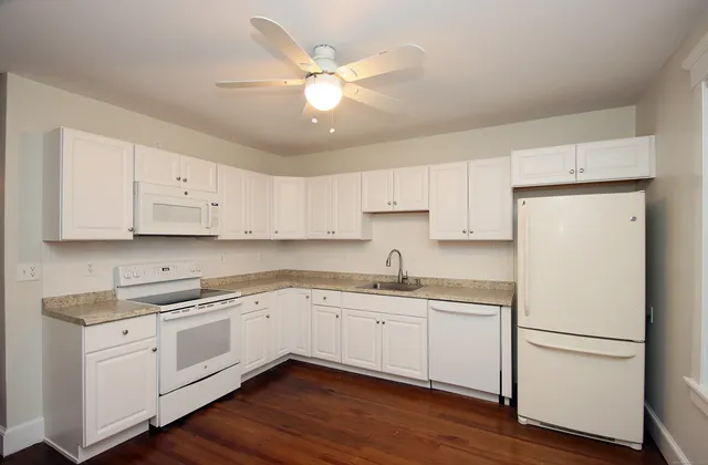 a kitchen with a sink a refrigerator and cabinets