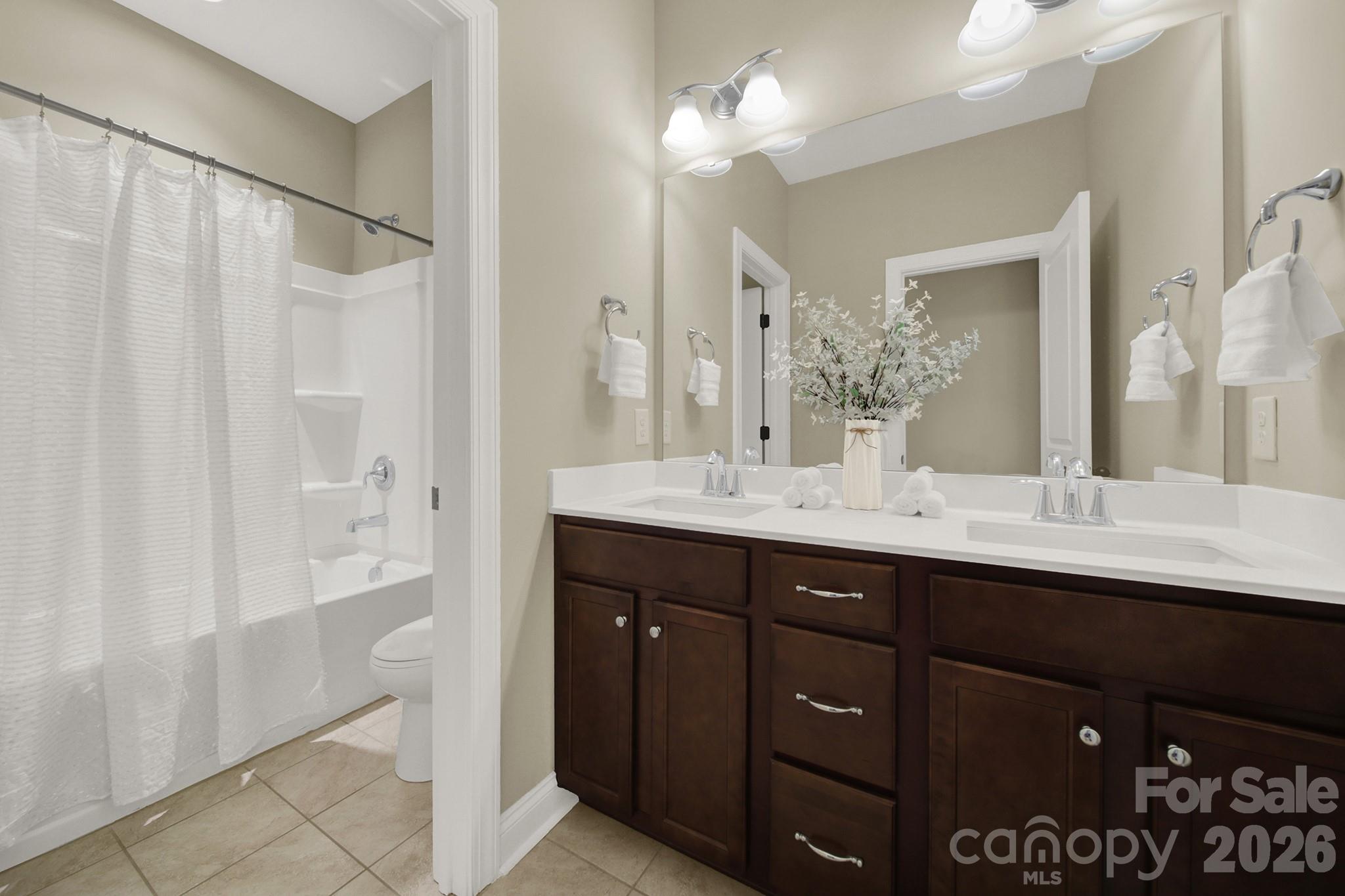989 Emory Lane Fort Mill, SC 29708 - Photo 30 of 48 a bathroom with a double vanity sink a large mirror and a bathtub