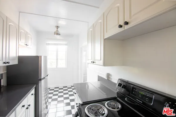 a kitchen with a refrigerator and a stove top oven
