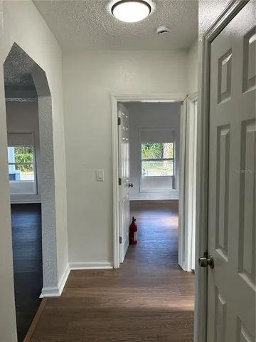 a view of a hallway view with wooden floor and a cabinet