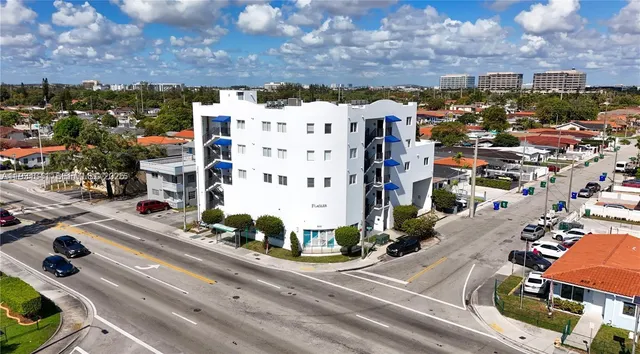 an aerial view of residential houses with outdoor space and parking