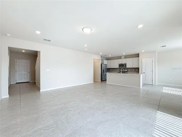 a view of open kitchen with a refrigerator a sink and a stove top oven