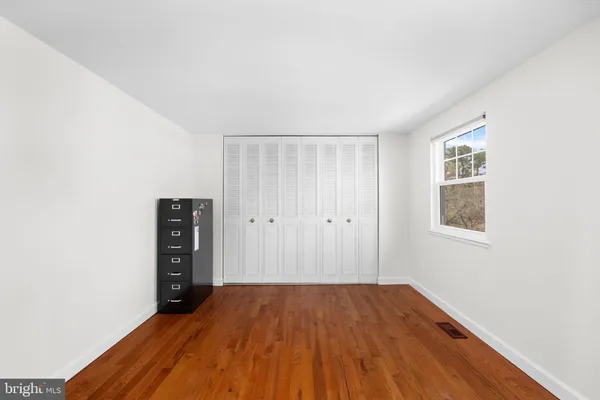 a view of a room with wooden floor and a window