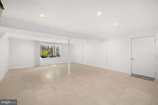 an empty room with windows and plants